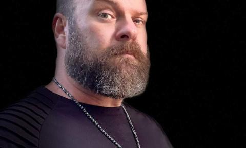 Paul Jensen poses in front of a black background. 