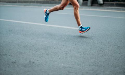 A man's legs rush toward the finish line. 