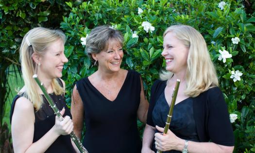 The members of the Vivace Trio from Jacksonville, standing outside near a flowered bush