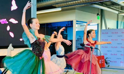 Four dancers, students of Raquel Rudi, perform on stage for friends and family