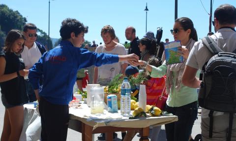 A teen sells lemonade at a stand
