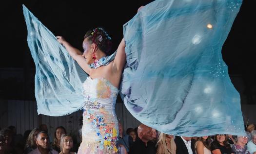 A runway model at the St. Augustine Love Your Mother Eco Fashion Show spreads her fabric wings