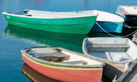 Small boats, and dinghies, painted in bright colors, tied to a river dock