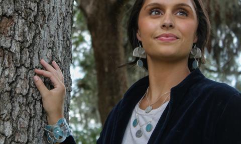 A model from rethreaded wearing jewelry crafted at that organization