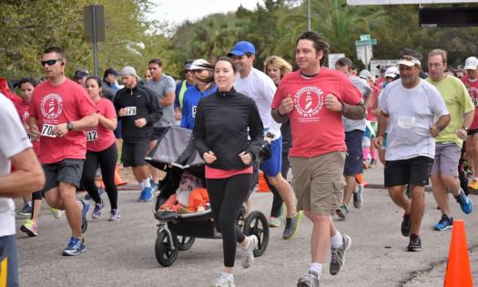 Runners in race-day t-shirts and athletic apparel running in the Lighthouse 5k and Fun Run