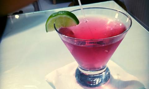 A cocktail topped with a lime on the rim