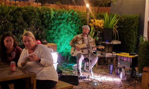 A musician performs outside at the Uptown Block Party