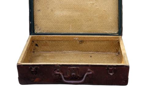 An old, brown suitcase, open and empty