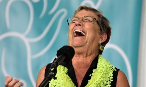 Pat Nease, a member of the St. Augustine Tale Tellers, laughs on stage as she relates one of her stories