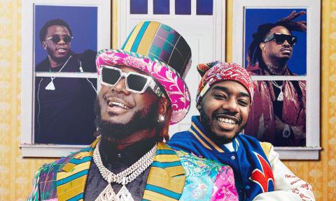 T-Pain smiles and poses in glasses and colorful clothing with a matching hat. 