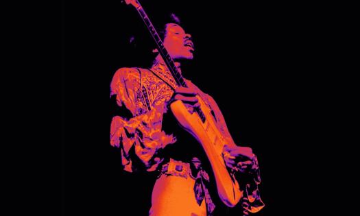 Jimi Hendrix performs on stage with his guitar. 