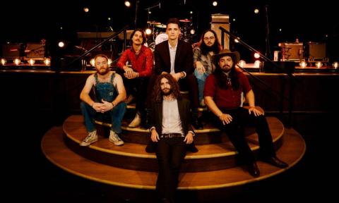 Bandmates from The Red Clay Strays pose on the steps of a stage.