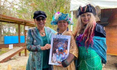 The author and two pirate-garbed women, with the book, "St. Augustine Sisterhood"