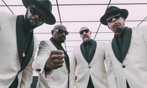 Bandmates from Cypress Hill don white and black suits and pose for fans. 