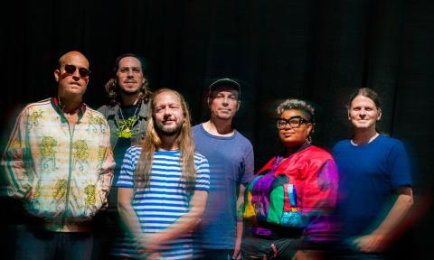The band Motet, standing together with a black background