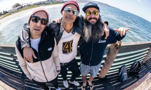 Bandmates from Pepper smile and pose on a pier.