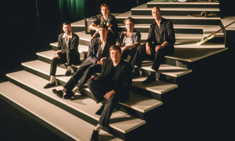 Bandmates from The Dip smile and pose on a staircase.