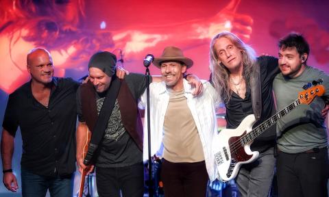 Tribute band Given To Fly onstage standing together, smiling