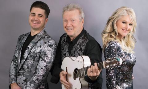 Peter White clutches his guitar and smiles alongside Mindi Abair and Vincent Ingala. 
