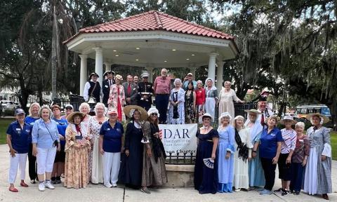 A group of people at the Plaza, some wearing colonial garb