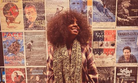 The award-winning vocalist Ledisi, standing in front of a wall of old concert posters