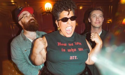 Members of Alabama Shakes stand together beneath warm, ambient lighting.