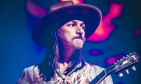 Duane Betts clutches his guitar and performs on stage.