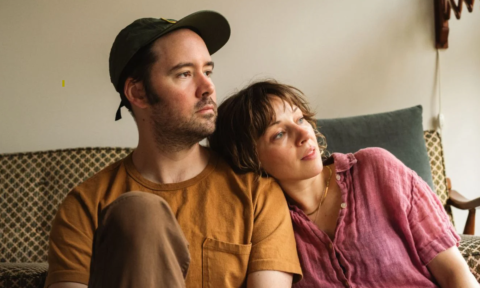 Bandmates from Watchhouse pose while sitting on a couch.