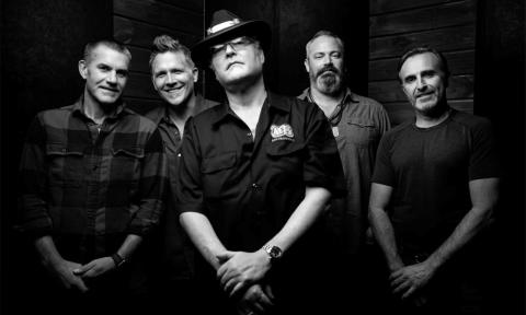 Bandmates from Blues Traveler pose in a black and white photograph.