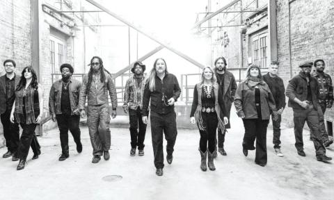 Bandmates from Tedeschi Trucks wear dark clothing and pose in a black-and-white photograph.