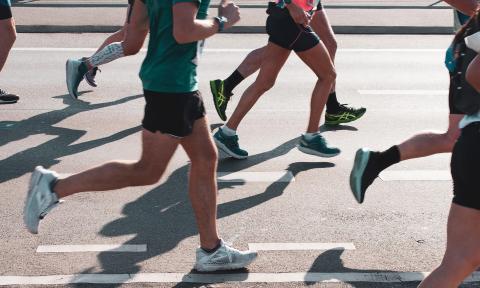 Race runners along a road, seen from the waist down