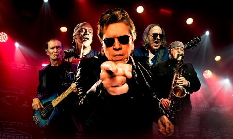 George Thorogood and The Destroyers pose and perform on stage.