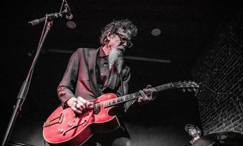 Walter Parks on stage with a red guitar