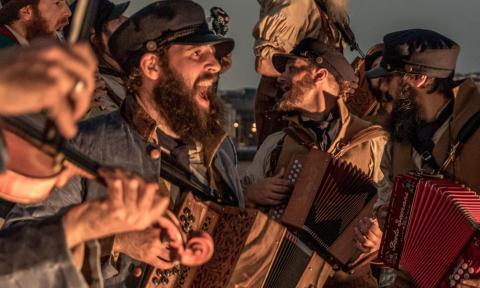 Bandmates from Old Time Sailors perform with their musical instruments.