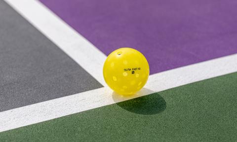 An Onix pickleball on a multi-colored court