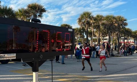 Two runners at the finish line at Santa Suits on the loose in 2025