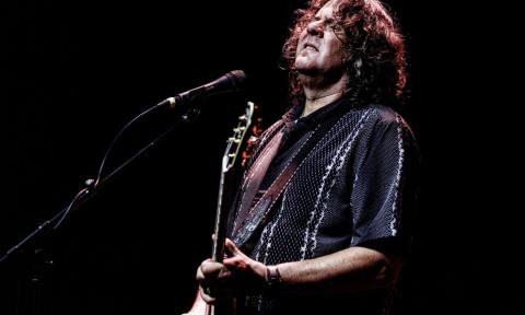 Sean Chambers performs live on stage with his guitar.