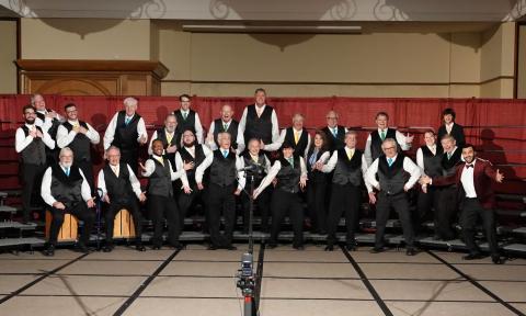 The Big Orange Chorus of barbershop singers, posing in fun