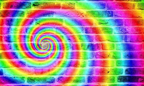 A 70s-style swirl in rainbow colors on a brick wall