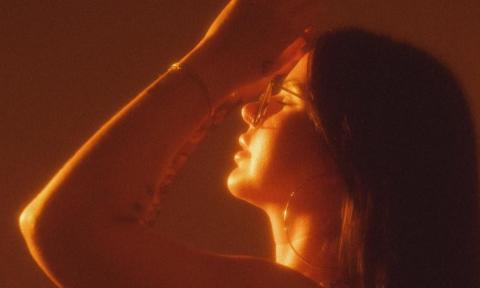 Caitlynne Jennings poses in front of a sepia backdrop.