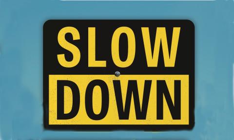 A road sign against a blue sky, Slow Down