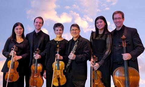 Members of the San marco Chamber Music Ensemble against a summer sky
