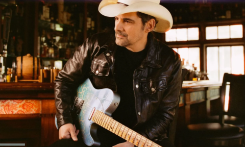 Brad Paisley poses with a white cowboy hat and matching guitar.