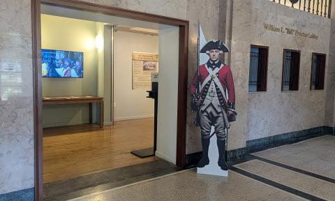 A cardboard British soldier from the Revolutionary War guards the entry to this exhibit