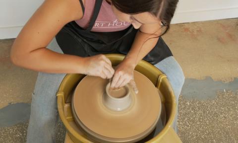 A woman shaping clay in a workshop