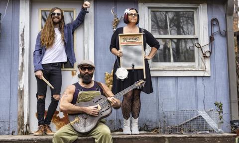 Bandmates from Reverend Peyton's Big Damn Band pose with their musical instruments.