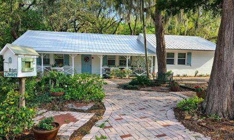 The exterior of the Garden Club of St. Augustine, a low white ranch house on a landscapped lot