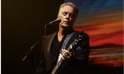 Shaun Cassidy strums his guitar and performs live on stage.