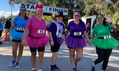 Five racers in fun clothing and tutus at the 5K Shine a Light