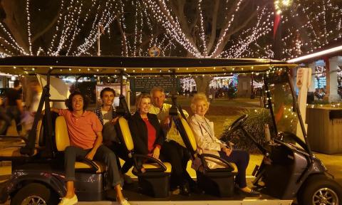 A Gold Tours electric EV with a family aboard for a Nights of Lights Tour